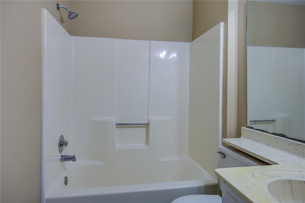 1457 Cherry Hill Road Southwest Conyers, GA 30094 - Photo 29 of 31 a bathroom with a granite countertop sink and a bathtub