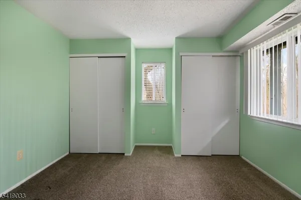 an empty room with a window and a kitchen