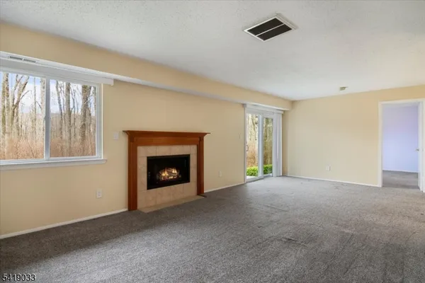 a view of an empty room with window and fire place