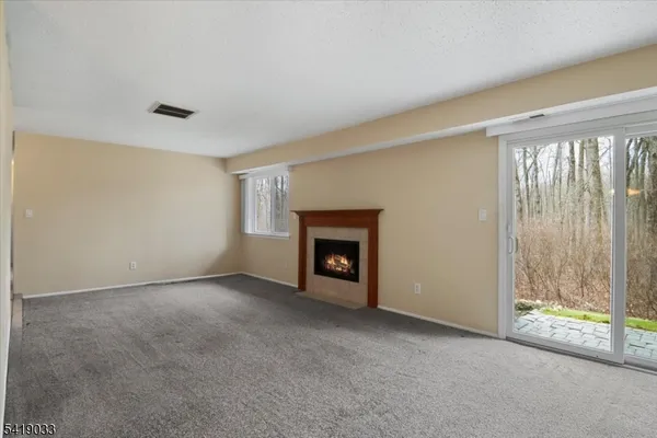 a view of an empty room with glass door and balcony
