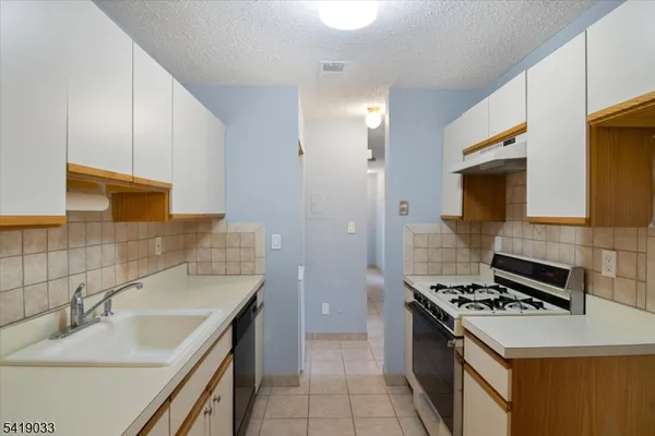a kitchen with a sink stove top oven and cabinets