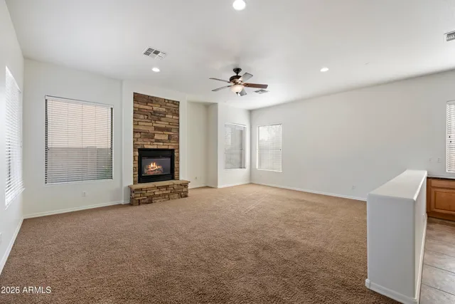 an empty room with windows and fireplace