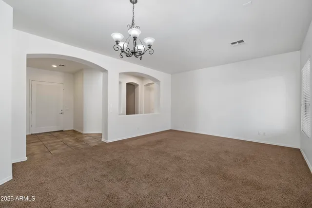 a view of an empty room with chandelier
