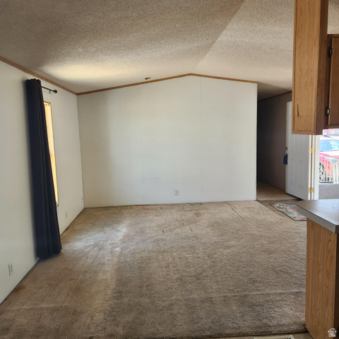3760 Gold Ridge Drive, Unit 82 Magna, UT 84044 - Photo 10 of 29 Spacious interior room featuring a vaulted ceiling and neutral wall tones