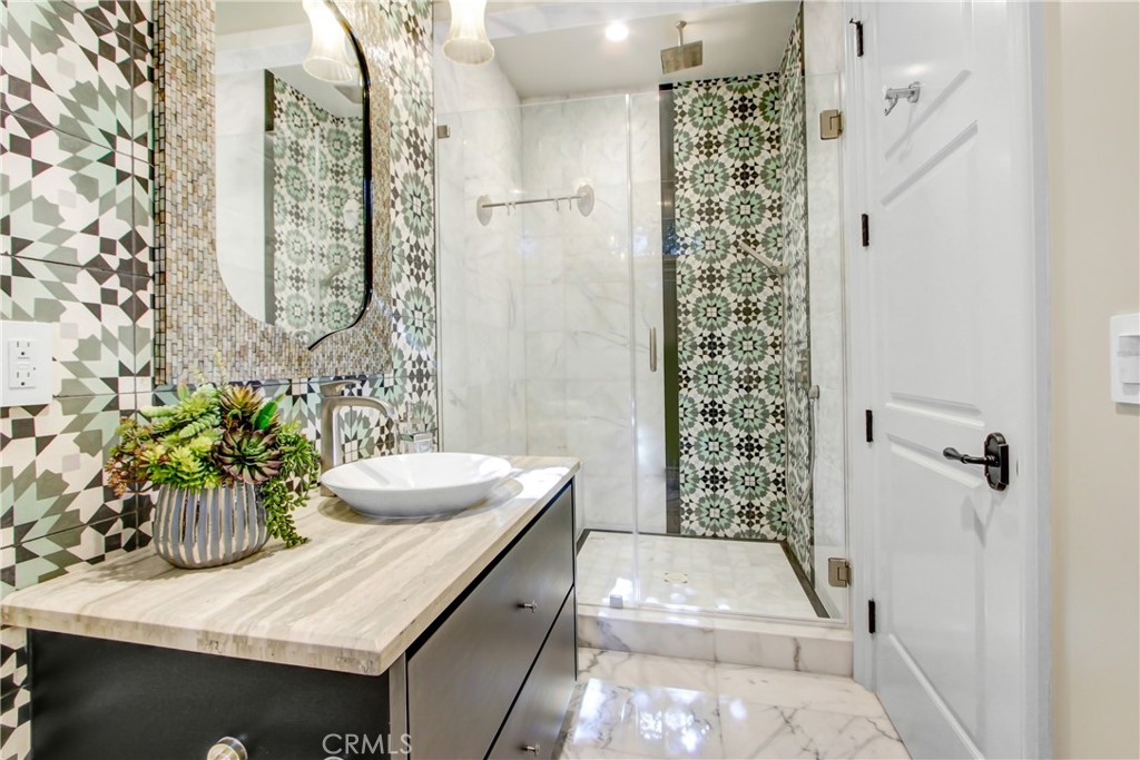 400 Santa Rosa Road Arcadia, CA 91007 - Photo 28 of 47 a bathroom with a granite countertop sink a mirror a vanity and a shower
