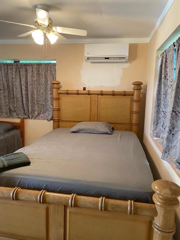 1587 Wayman Road Moore Haven, FL 33471 - Photo 3 of 7 a bed sitting in a bedroom next to a window with a chandelier
