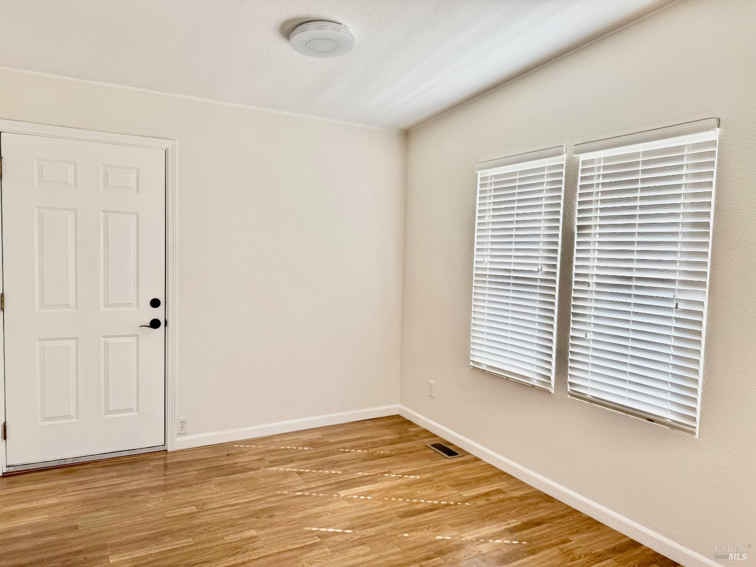 1945 Piner Road, Unit 16 Santa Rosa, CA 95403 - Photo 7 of 21 a view of an empty room with wooden floor and a window