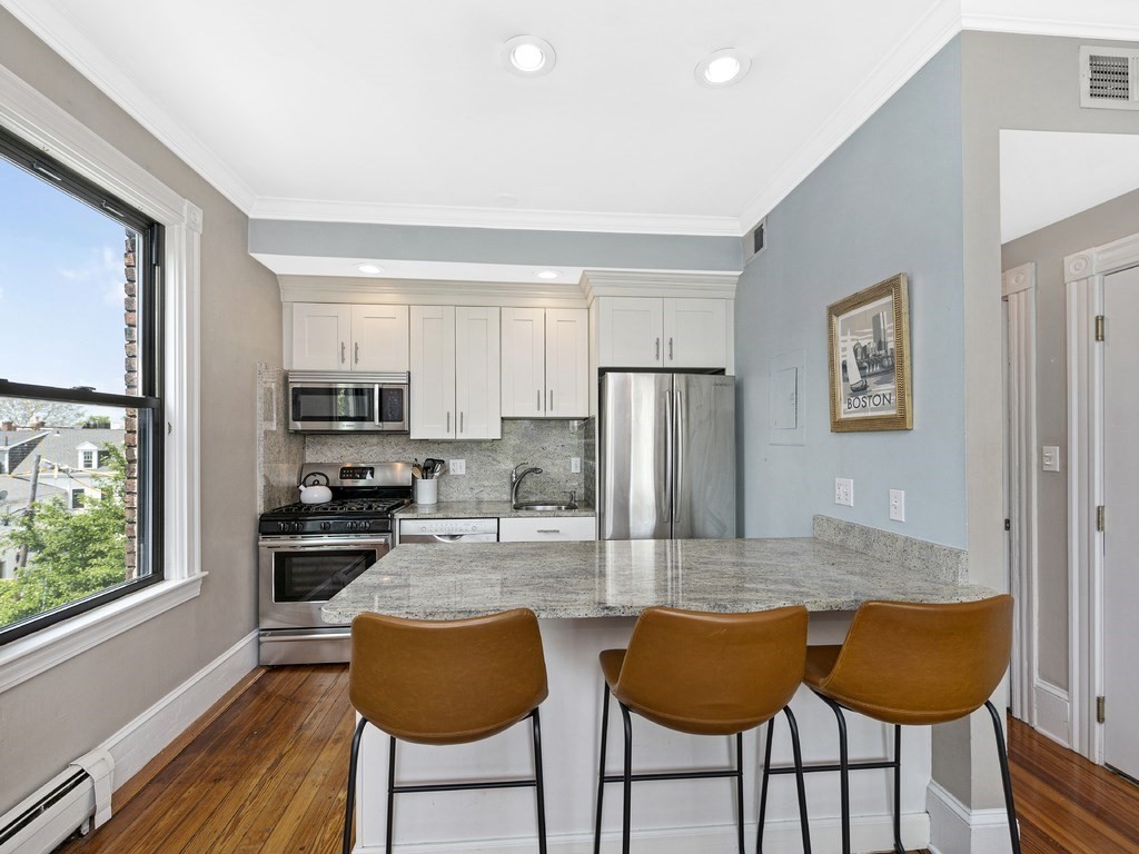 58 Winthrop Street, Unit 3 Boston, MA 02129 - Photo 4 of 14 a kitchen with stainless steel appliances granite countertop a refrigerator and a stove top oven
