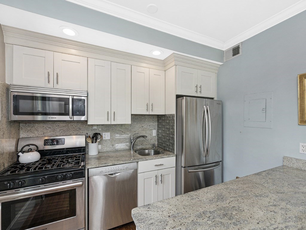 58 Winthrop Street, Unit 3 Boston, MA 02129 - Photo 6 of 14 a kitchen with stainless steel appliances granite countertop a refrigerator stove a sink and dishwasher a oven with white cabinets