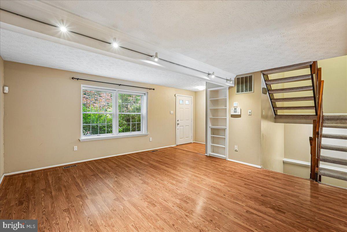2331 Middle Creek Lane Reston, VA 20191 - Photo 13 of 78 a view of an empty room with wooden floor and a window
