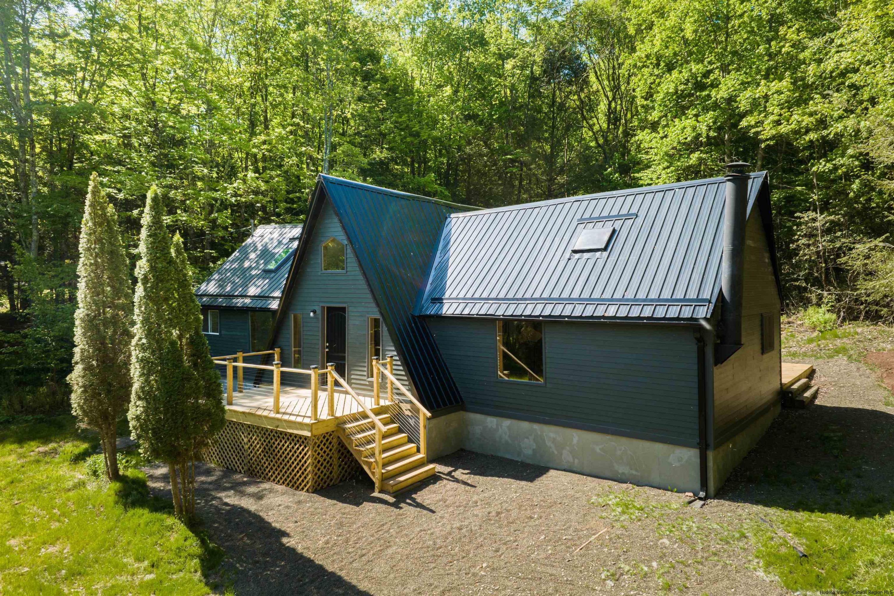 356 Mink Brook Road Colchester, NY 13755 - Photo 1 of 25 a view of a house with backyard porch and sitting area