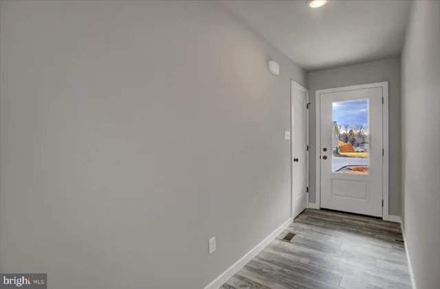 a view of a hallway with wooden floor and a window