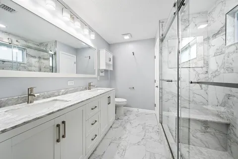 a spacious bathroom with a granite countertop sink mirror and toilet
