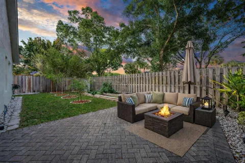 a view of a backyard with couches table and chairs and potted plants
