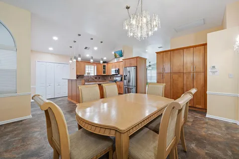 a view of a dining room with furniture and chandelier