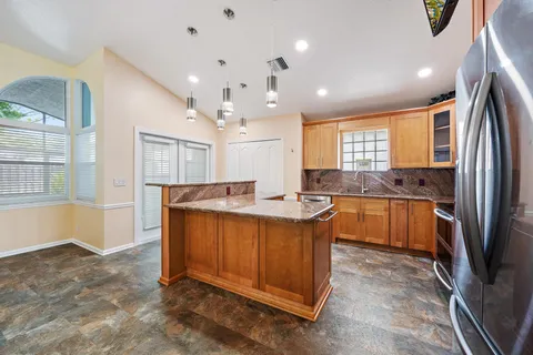 a large kitchen with kitchen island a large counter space appliances and a window