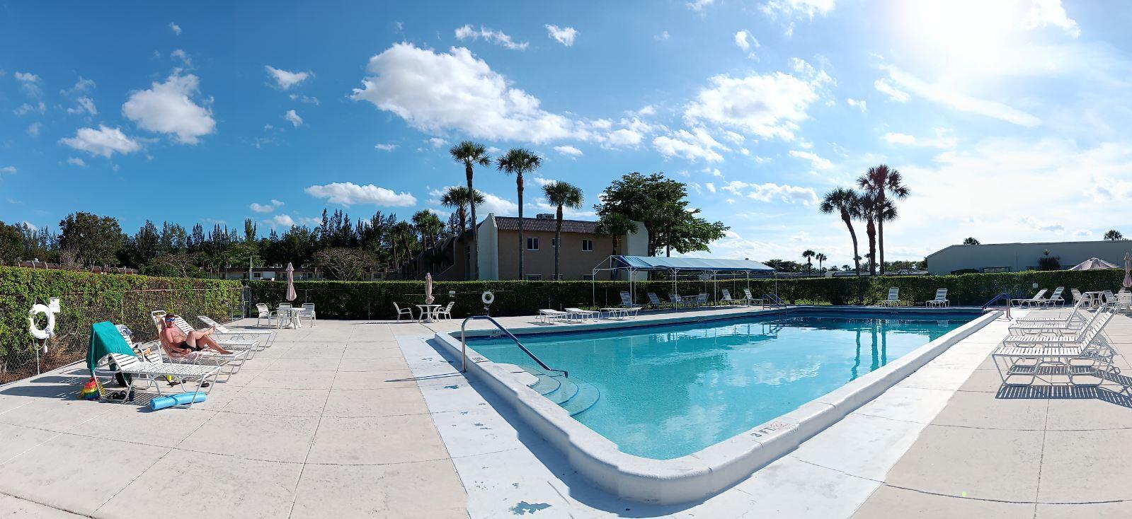 154 Lake Meryl Drive, Unit 257 West Palm Beach, FL 33411 - Photo 24 of 25 a view of a swimming pool with a lounge chairs