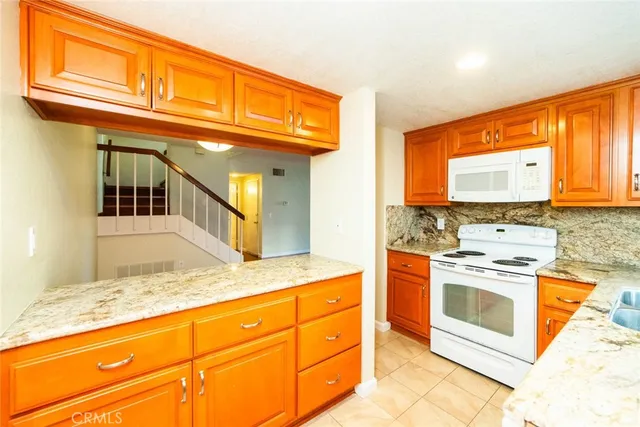 a kitchen with stainless steel appliances granite countertop a stove a sink and a microwave