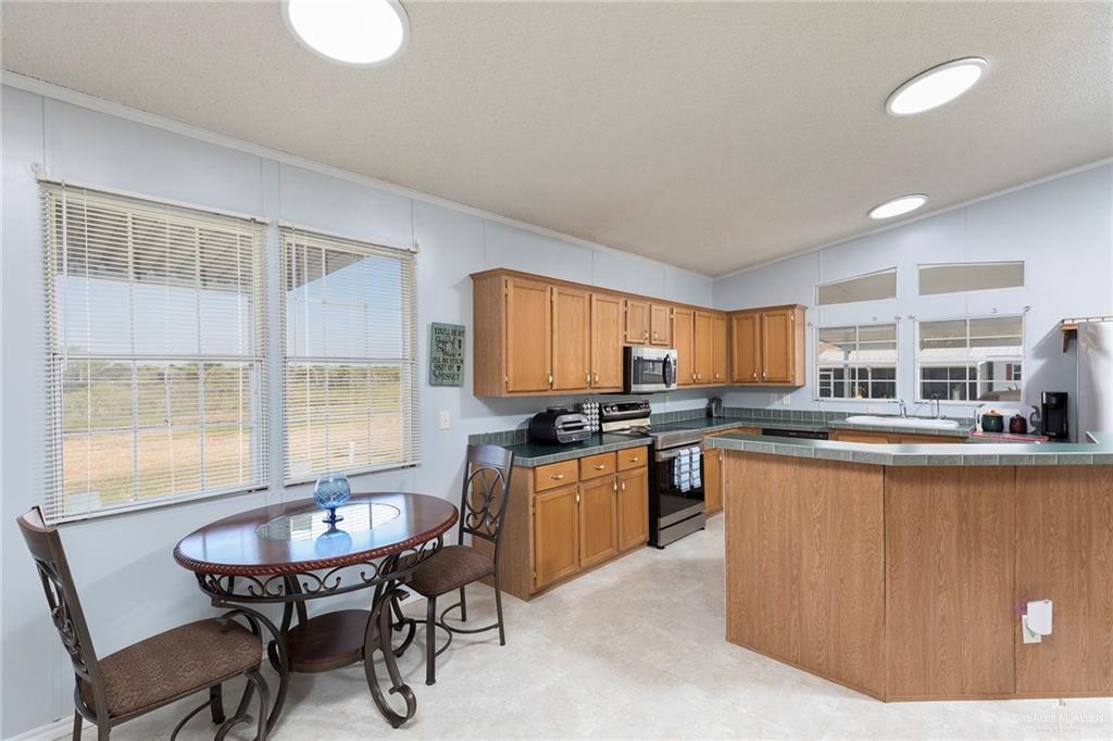 1034 Santa Maria Street Mercedes, TX 78570 - Photo 12 of 25 a kitchen with granite countertop a sink and a stove top oven