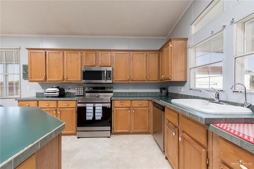 1034 Santa Maria Street Mercedes, TX 78570 - Photo 13 of 25 a kitchen with stainless steel appliances granite countertop a sink stove and microwave