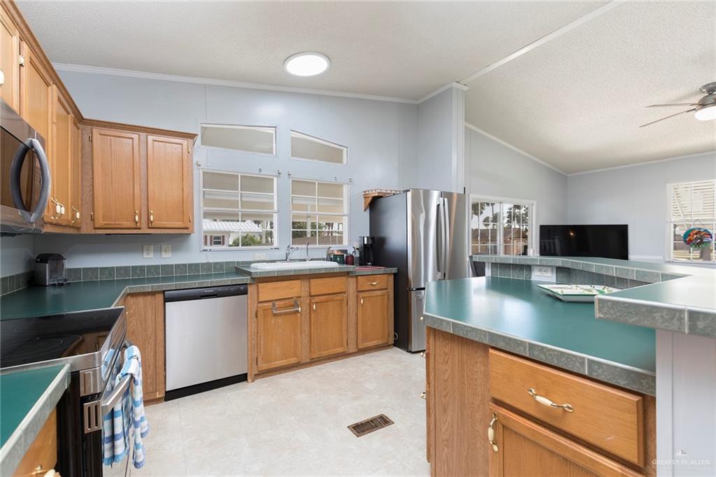 1034 Santa Maria Street Mercedes, TX 78570 - Photo 14 of 25 a kitchen with stainless steel appliances granite countertop a refrigerator sink and microwave