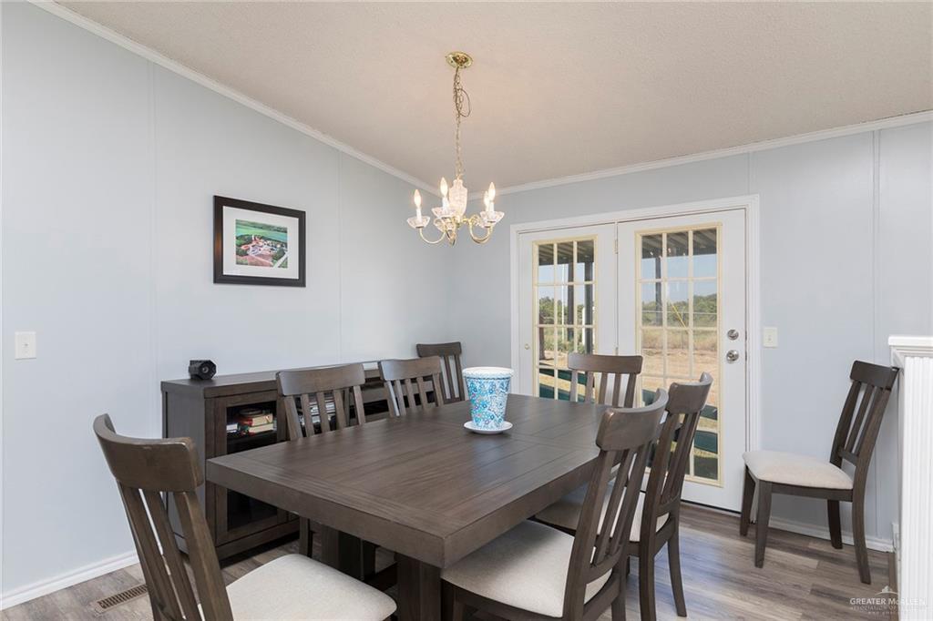 1034 Santa Maria Street Mercedes, TX 78570 - Photo 7 of 25 a view of a dining room with furniture a chandelier and wooden floor