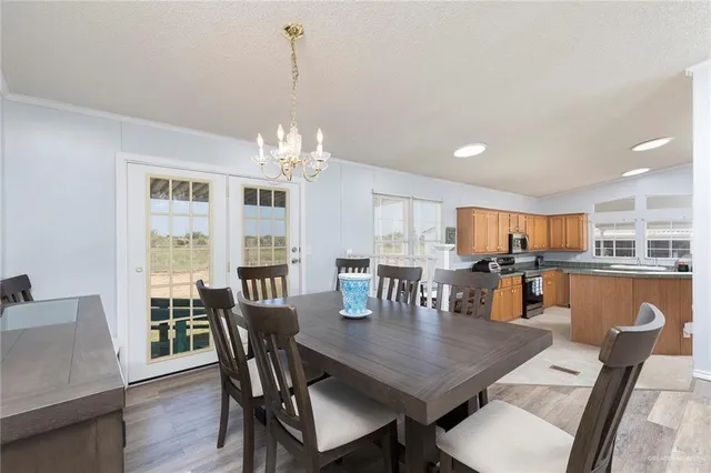 a dining room with furniture a chandelier and wooden floor