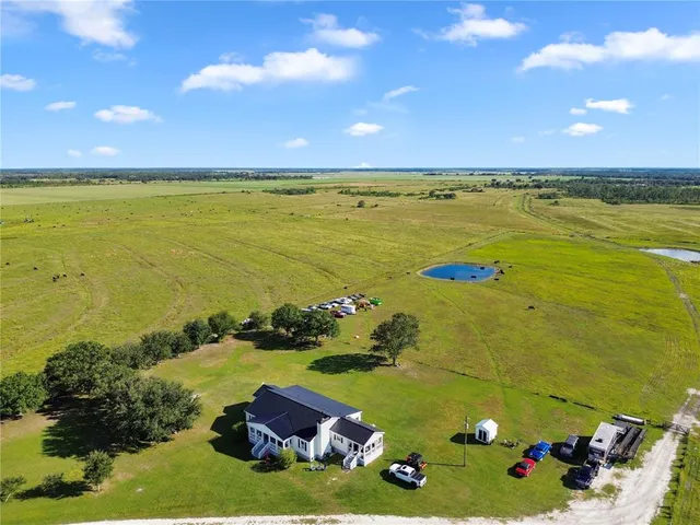 a kitchen with stainless steel appliances kitchen island granite countertop a refrigerator a stove top oven a sink dishwasher and white cabinets with wooden floor