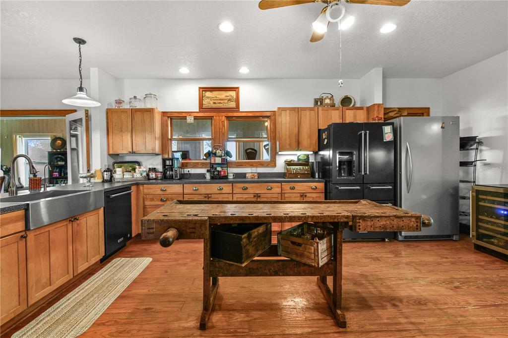 10807 Northwest Lily County Line Road Ona, FL 33865 - Photo 48 of 91 a kitchen with stainless steel appliances kitchen island granite countertop a table chairs and a refrigerator