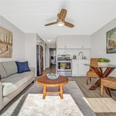 a living room with furniture kitchen view and a window