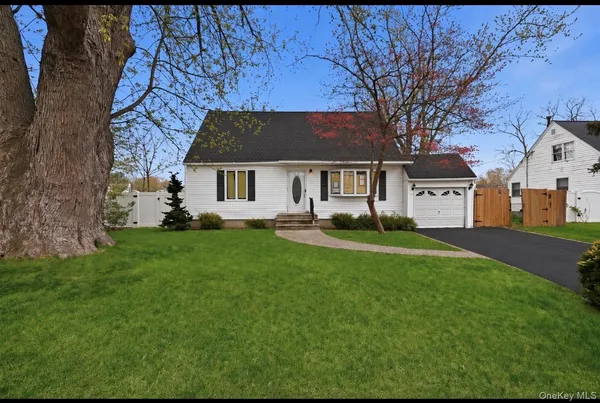 a front view of a house with a yard and trees
