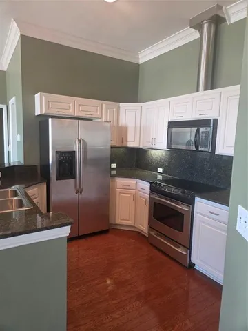 a kitchen with granite countertop a refrigerator and a stove