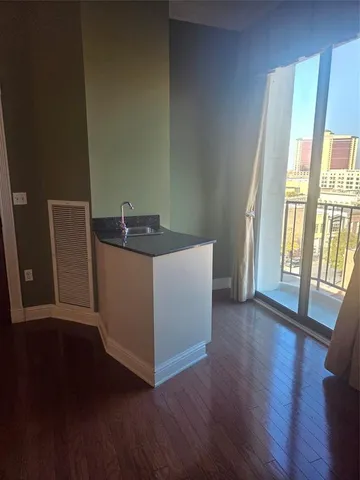 a kitchen with granite countertop white cabinets and wooden floor