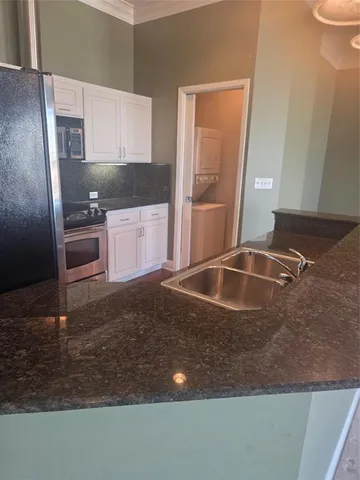 a kitchen with a sink a refrigerator and a stove