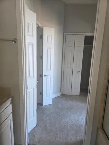a view of hallway with closet and wooden floor