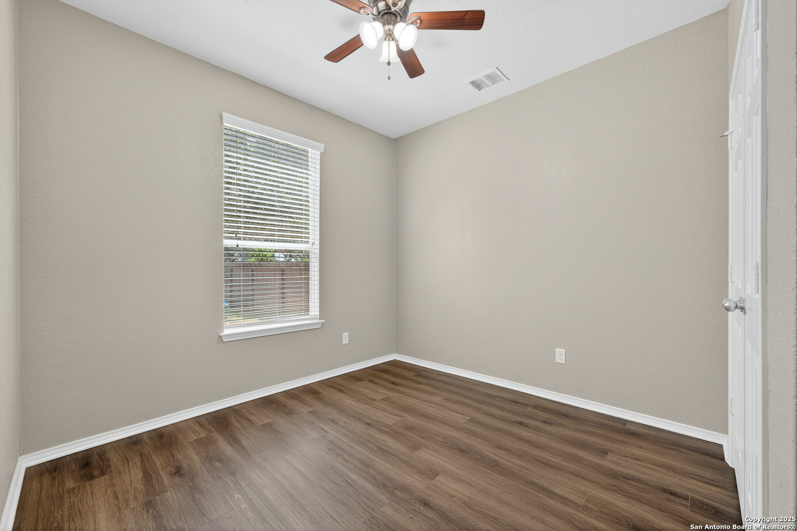 474 Walnut Crest Selma, TX 78154 - Photo 12 of 28 an empty room with wooden floor chandelier fan and windows