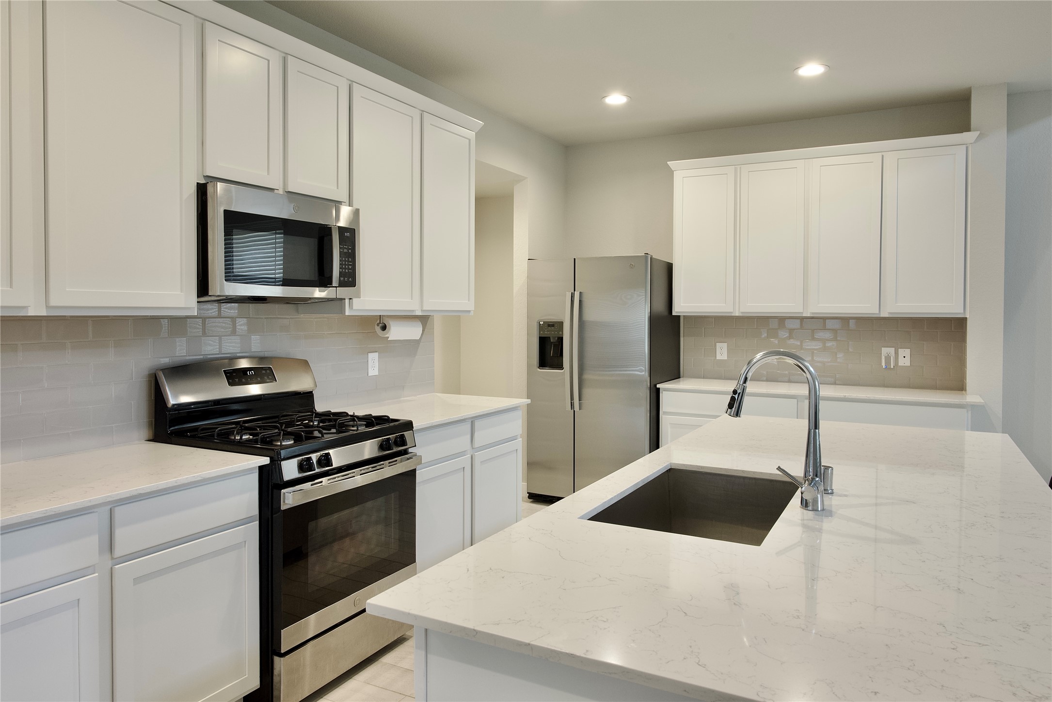 3207 Tilley Drive Rosenberg, TX 77471 - Photo 10 of 43 a kitchen with stainless steel appliances a stove a sink a microwave and cabinets