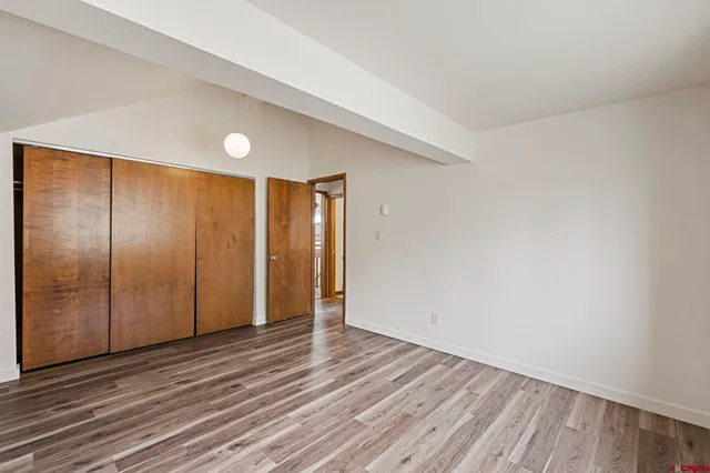 a view of an empty room with wooden floor