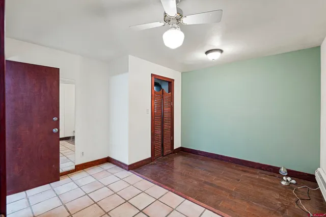 an empty room with windows and fan