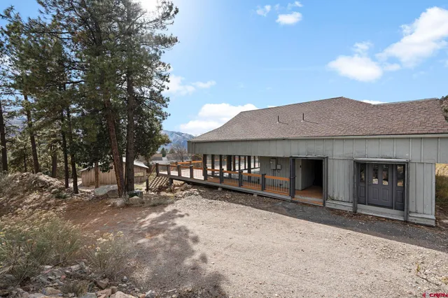 a view of a house with a big yard and large tree