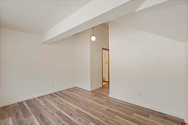 a view of an empty room with wooden floor