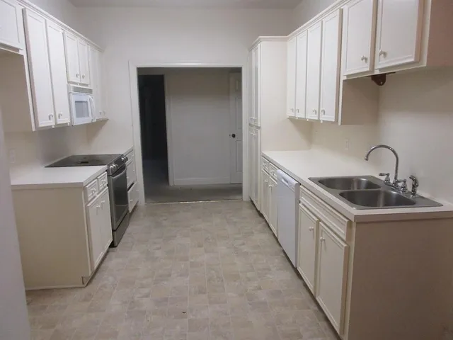 a kitchen with granite countertop a sink and cabinets