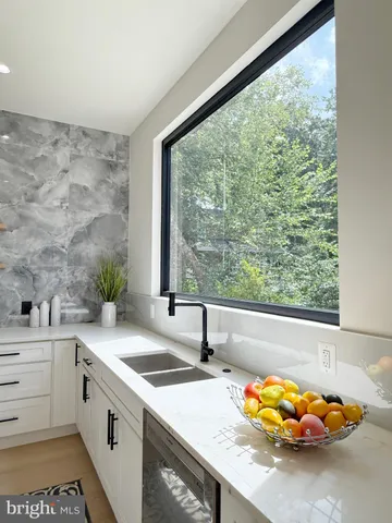 a view of a kitchen with a sink and large window