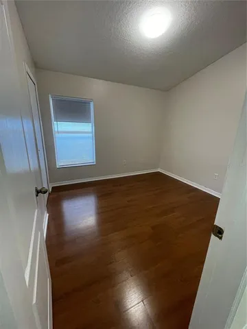 an empty room with wooden floor and door