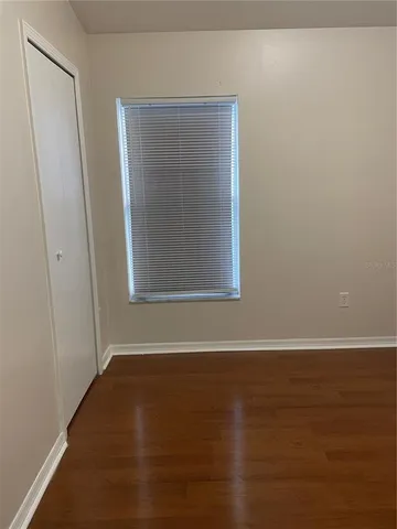 a view of a small space with wooden floor and a window