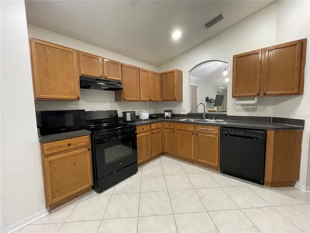 a kitchen with stainless steel appliances granite countertop a stove sink and cabinets