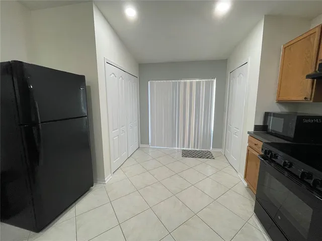 a kitchen with a refrigerator and a stove top oven