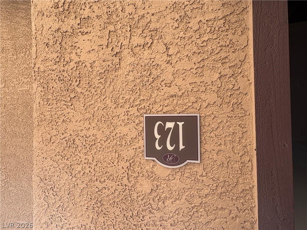 9325 West Desert Inn Road, Unit 123 Las Vegas, NV 89117 - Photo 4 of 36 A numbered address plaque on a textured stucco wall provides clear identification.