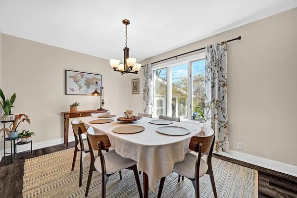 a view of a dining room with furniture a chandelier and wooden floor
