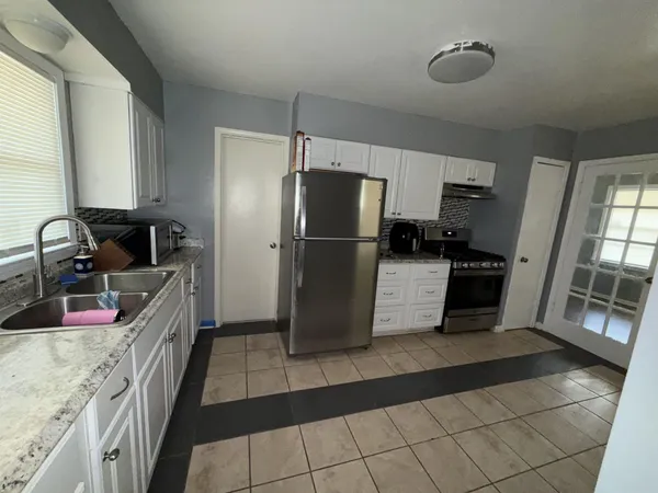 a kitchen with granite countertop a refrigerator and a sink
